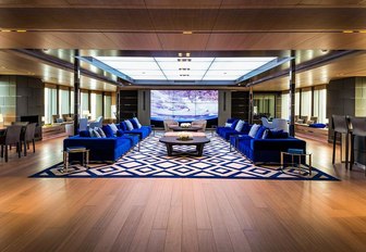 main salon on bold yacht, with large tv screen and blue sofas