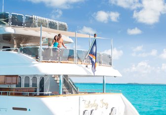 charter guests admire the views from the upper deck aft of luxury yacht Lady Joy 
