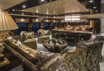 opulent main salon with gold-coloured seating on board motor yacht ‘Lady Bee’