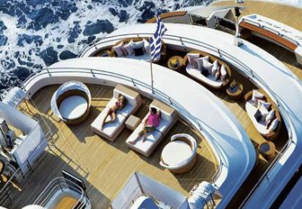 people relaxing on one of the decks of superyacht o'mega as seen from an aerial perspective