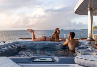 charter guests sip champage while unwinding in the Jacuzzi on board motor yacht TOUCH
