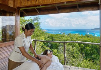A female guest getting a massage at the luxury resort on the private island of Petit St Vincent, Caribbean