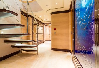 lower deck hallway with floating staircase and wall mural aboard sailing yacht Q