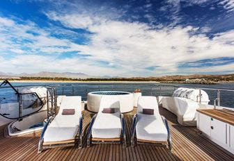 expansive deck space with sun loungers and jacuzzi onboard yacht Komokwa