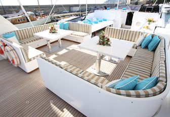 Twin alfresco seating spaces on superyacht HEMILEA, with wraparound sofas and elegant cocktail tables