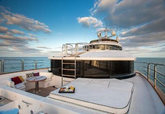 seating area and sunpads on the master suite's private terrace on board luxury yacht CHECKMATE 