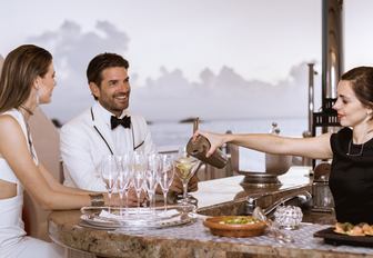 charter guests are served drinks at the bar on board superyacht TITANIA 
