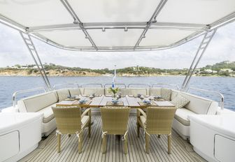 alfresco dining area covered by a bimini on the upper deck aft of luxury yacht OASIS
