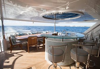 sleek bar and alfresco dining area looked over by a skylight aboard luxury yacht SERENITY