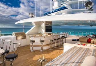 bar on superyacht sundeck, with sunpad spread and bahamas in background