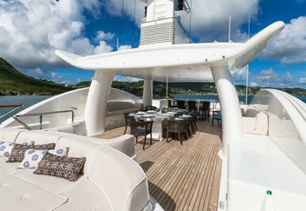 oversized sunpads and dining table on the sundeck of charter yacht DENIKI