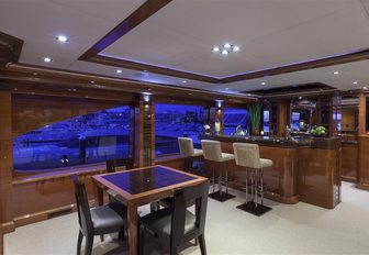 Sky lounge with table and chairs, and corner bar on board motor yacht Aspen Alternative