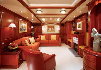 main salon on board charter yacht METEOR with rich woods and wood-burning fireplace