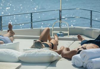 guests sunbathing on the foredeck of motor yacht December Six 