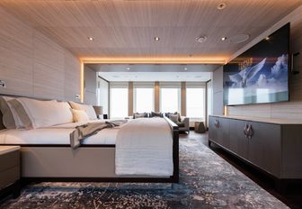 full-beam master suite with huge bed, TV and floor-to-ceiling windows aboard charter yacht LAURENTIA 