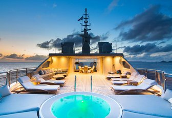 charter yacht om'mega's sun deck fit with jacuzzi and sun loungers just as the sun set over the horizin in the caribbean