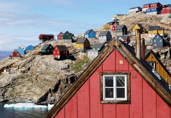 colourful houses line the rocky shoreline in Greenland