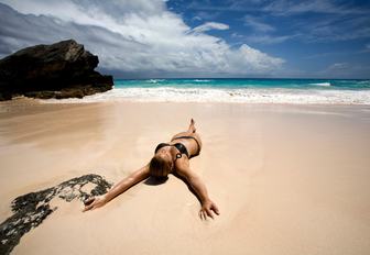woman sunbathes on white sand beach of Horseshoe Bay in Bermuda