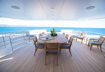spacious upper aft deck of charter yacht JACOZAMI with large dining table and lounge areas
