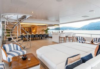 sunning station and alfresco dining table on the aft deck of motor yacht Joy