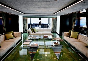 three sofas and a green coffee table form the seating area in the main salon of luxury yacht SARASTAR 