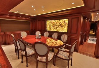 formal dining setup with wooden table in the main salon of charter yacht CLARITY 