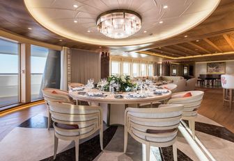 circular dining table in the main salon aft on board luxury yacht Here Comes The Sun 