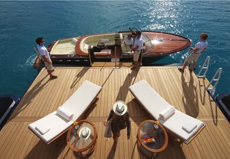 Beach club of luxury yacht amaryllis with sun loungers and tenders aerial shot