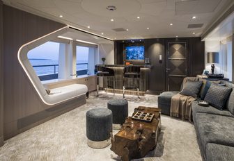 skylounge on board motor yacht irisha, with wooden table and L-shaped seating integrated into portside