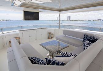 U-shaped seating area facing drop-down TV on the sundeck of superyacht The Rock 