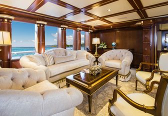 Cream sofas and coffee table with gold furnishings in main salon of charter yacht my seanna