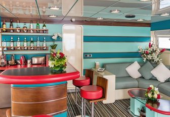 turquoise and pink-coloured skylounge with corner bar aboard luxury yacht ‘Cheetah Moon’ 