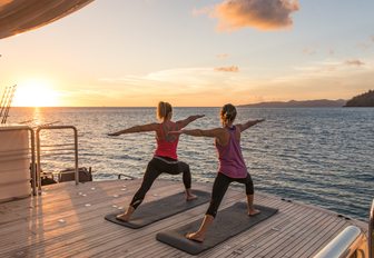women practicing yoga on luxury yacht spirit