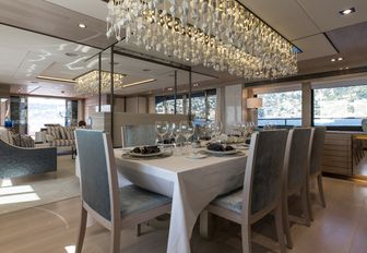 formal dining area looked over by glittering light fixture aboard charter yacht THUMPER 