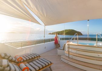 Jacuzzi and chaise loungers covered by a sun awning on the sundeck of superyacht BACCHUS 