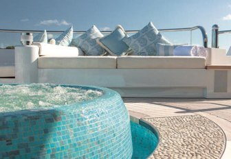 Jacuzzi in foreground and sofas behind on owner's deck of luxury yacht Solandge