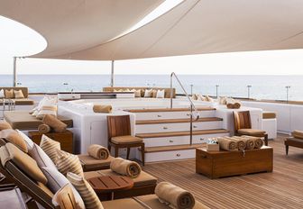 step-up Jacuzzi and sun loungers on the sundeck of charter yacht SURI