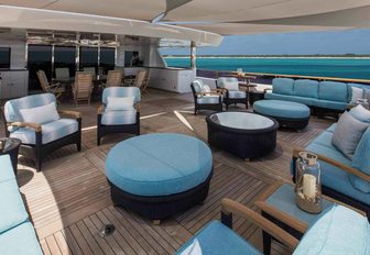 expansive upper deck aft with seating areas and dining table aboard motor yacht UNBRIDLED 