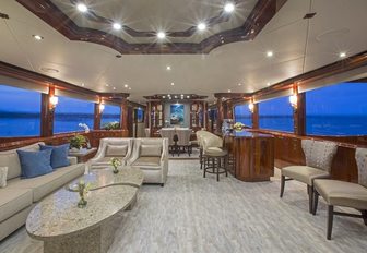 sophisticated main salon with sociable lounge and bar aft aboard motor yacht ‘Gale Winds’ 