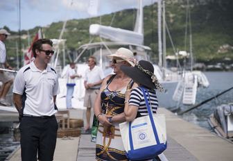 show-goers talk to a crew member on the boardwalks at the Antigua Charter Yacht Show