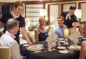 charter guests dining in the main salon aboard charter yacht BACCHUS 