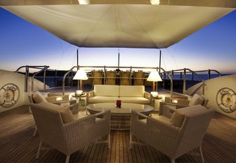 a chic seating area under the cover of a Bimini on the sundeck of motor yacht JAGUAR at night