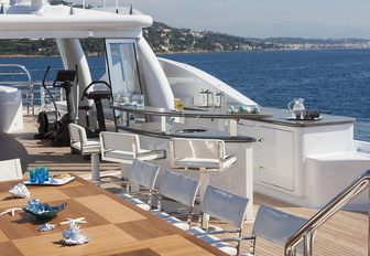 dining table, bar and exercise equipment on the sundeck of luxury yacht 4YOU
