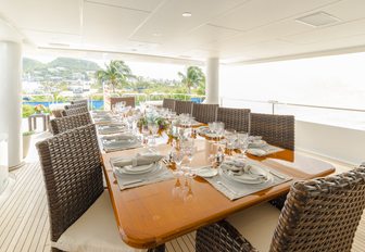 rectangular al fresco dining table on the upper deck aft of charter yacht One More Toy 