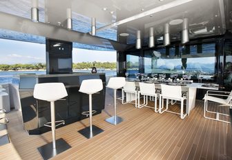 sleek bar and alfresco dining option on upper deck of motor yacht JURATA 