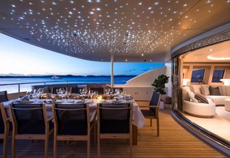 al fresco dining area on the upper deck aft with LED lights lit up in overhang of the deck above on board superyacht G3