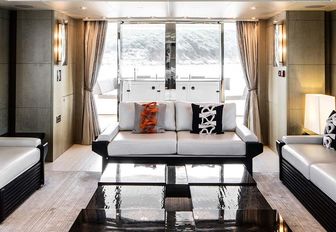 Comfortable seating with large glass doors behind on motor yacht Oksanchik