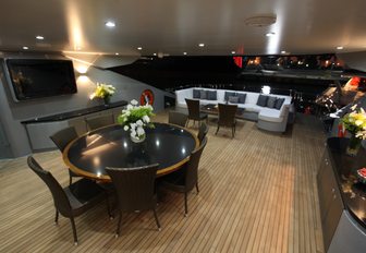 alfresco dining area on m/y grey matters with table in foreground and seating area in background