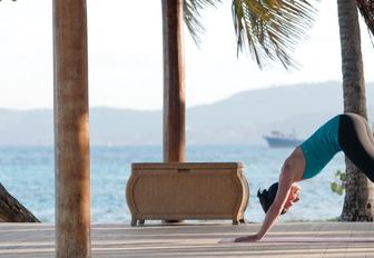 A woman in a yoga pose at the luxury resort on the private island of Petit St Vincent, Caribbean