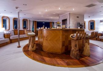 bar on upper deck aft of charter yacht SHERAKHAN with wooden bar stools shaped like hands